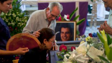 Ofelia Acevedo (segunda a la izq.), viuda del activista Oswaldo Payás, es consolada por un hombre no identificado frente al féretro, en la misa fúnebre que tuvo lugar en La Habana, Cuba,