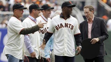 Barry Bonds, de los Gigantes de San Francisco, segundo desde la derecha, habla con el presidente y CEO Larry Baer.
