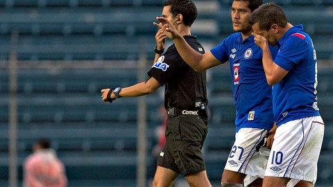 Christian Giménez abandona el campo con la mano en el rostro para cubrir su gesto de dolor mientras Javier Orozco lo consuela.