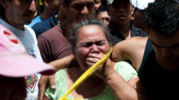 Esta mujer llora tras asesinato de Juan José Godínez, en Ciudad de Guatemala, quien trabajaba en   transporte extraurbano, ayer.