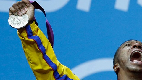 Óscar Albeiro Figueroa da rienda suelta a su júbilo sobre el podio tras recibir su medalla plateada que ganó en la división de 62 kilogramos.