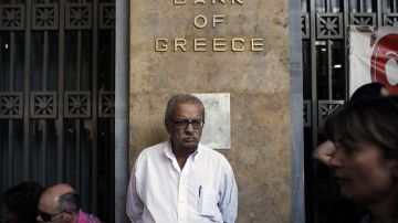 Empleados del sector bancario protestan a las afueras de una sede cerrada del Banco Nacional de Grecia en Atenas, ayer.