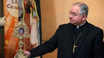 El arzobispo José Gómez muestra lo que él llama 'una reliquia de la tilma de la imagen original de la virgen'.