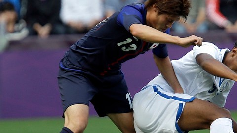 Mario Martínez protege el balón ante el acoso del japonés Daisuke Suzuki en un pasaje del partido de ayer entre Honduras y Japón.