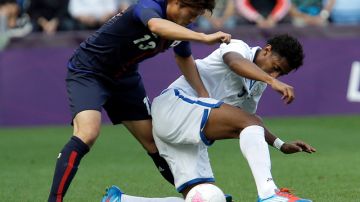 Mario Martínez protege el balón ante el acoso del japonés Daisuke Suzuki en un pasaje del partido de ayer entre Honduras y Japón.