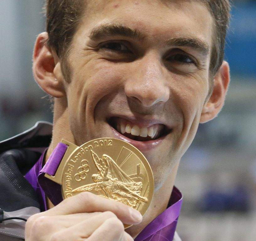 Michael Phelps con su medalla de oro número 17.