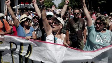 Empleados del ATEbank (Banco de Agricultura de Grecia) gritan lemas durante una protesta en el centro de Atenas.