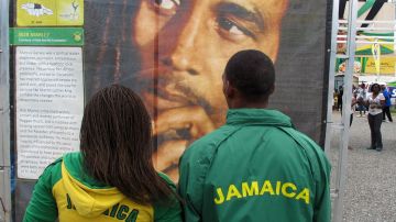 Jóvenes miran una foto de Bob Marley en Jamaica.