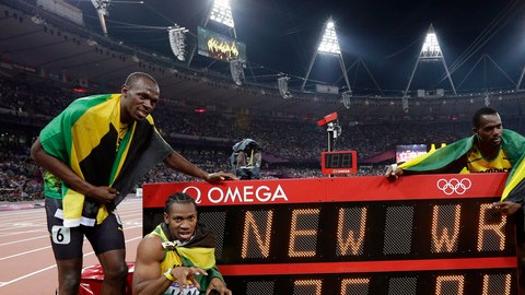 Bolt (izq.)  Yohan Blake, Nesta Carter y Michael Frater (der.) posan en la pizarra que anuncia su marca.