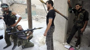 Rebeldes sirios vigilan su posición durante la lucha contra los seguidores de Bachar al Asad, en Alepo (Siria), ayer.