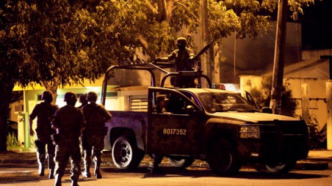Soldados del Ejército mexicano caminan hacia sus vehículos después de encontrar siete cuerpos dentro de una camioneta en  Veracruz.