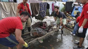 Un grupo de voluntarios australianos trasladan basura  en Quezón al este de Manila después de las inundaciones.