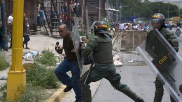 Guardias impiden el paso del fotógrafo venezolano,  de 'El Carabobeño', Gustavo Ortiz (i), a las cercanías de la cárcel El Rodeo.