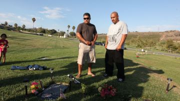 Héctor Rodriguez (i), y  George Rodríguez visitan la tumba de su hermano, César Rodríguez, en el cementerio Rose Hills.