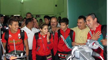 Germán Sánchez (izq.), Alejandra Orozco, Iván García y el entrenador Iván Bautista (der.) lucen felices a la salida del aeropuerto.