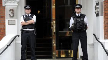 Dos policías hacen guardia en la entrada de la embajada de Ecuador donde el fundador de Wikileaks permanece tras pedir asilo político.