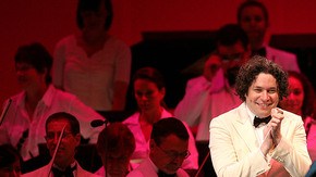 Juan Luis Guerra (centro) saluda a Gustavo Dudamel y la Filarmónica de Los Ángeles en el concierto del martes por la noche.