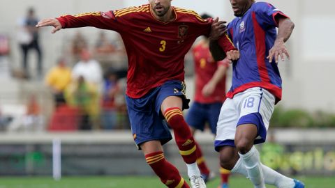 El español Gerad Piqué (izq.) pelea el balón con el jugador de Puerto Rico, Héctor Ramos, en el duelo de ayer que se jugó en la isla.