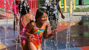 Unos niños disfrutan resfrescarse en una fuente en medio de la ola de calor que azotó recientemente a California.