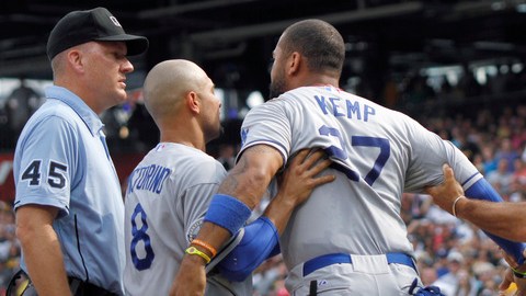 Matt Kemp (centro) es detenido por Shane Victorino (8) y Trey Hillman mientras le grita a uno de los umpires que lo expulsó del juego.