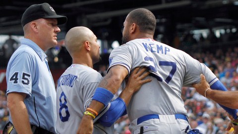 Matt Kemp (centro) es detenido por Shane Victorino (8) y Trey Hillman mientras le grita a uno de los umpires que lo expulsó del juego.