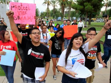 Joshua Montano, izquierda, y Deborah Robles protestan frente al Capitolio de Phoenix, un día después de que la gobernadora de Arizona, Jan Brewer, diera la orden de negar permisos de conducir a beneficiarios de la acción diferida..