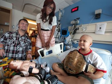 El luchador del World Wrestling Entertainment,  Hornswoggle (iz) y  Alicia Fox, visitan al pequeño paciente  Evan Gabor en el hospital  Mattel Children's Hospital UCLA, donde distribuyeron juguetes y sonrisas a los niños.
