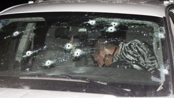 Un policía especial inspecciona  un vehículo tras un enfrentamiento con miembros del crimen organizado en el estado de Jalisco.