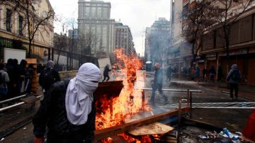 Estudiantes lanzaron piedras y palos a los policías y provocaron incendios en la protesta de ayer, en Santiago de Chile.