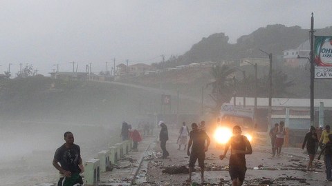 La gente corre sobre un puente golpeado por fuertes olas, debido a la tormenta tropical 'Isaac', en República Dominicana, ayer.