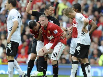 Wayne Rooney es cuestionado por su compañero Robin Van Persie sobre la cortada sufrida en el muslo derecho en Old Trafford.