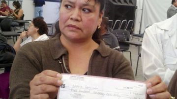Obdulia Martínez muestra el cheque sin fondos que recibió como pago en una fábrica de costura que cerró sin  avisar.