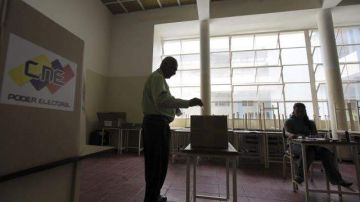 Un hombre deposita su voto en una urna durante el ensayo general previo a las elecciones presidenciales, en Venezuela.