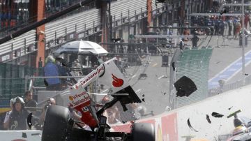El bólido de Fernando Alonso salta en pedazos después de chocar con el Mercedes del inglés  Lewis Hamilton, en  la primera vuelta.