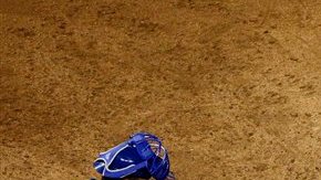 Michael Young de los Rangers cruza el home frente a Salvador Pérez de los Reales.