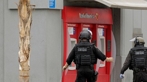 Miembros del escuadrón antibombas revisan el área cercana al banco  asaltado, en busca de explosivos, con resultados negativos.