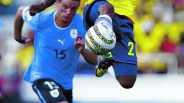 Mcanelly Torres, de Colombia, controla la pelota ante el esfuerzo del volante uruguayo Diego Pérez en el partido eliminatorio de ayer.