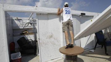 El dueño de una cabaña que quedó sin techo en el Club de Surf Breezy Point, en Nueva York, revisa los daños causados por un tornado.