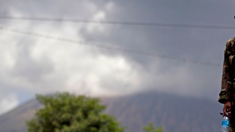 Un soldado nicaragüense con máscara, mientras el volcán San Cristóbal lanza espiras de humo y cenizas, en Chinandega, Nicaragua, ayer.