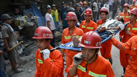 Rescatistas transportan a una víctima herida por uno de los terremotos en el pueblo de Luozehe, en Yiliang.
