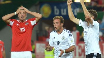 Gotze y Müller de Alemania celebran frente a la incredulidad de los jugadores de Austria en duelo eliminatorio para el mundial de Brasil 2014.