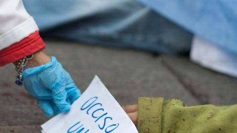 Un especialista forense coloca un pedazo de papel en el que se dice 'occiso uno', cerca de uno de los cuerpos, después del intento de robo a un vehículo blindado que llevaba dinero hacia una tienda por departamentos, en Ciudad de México, ayer.
