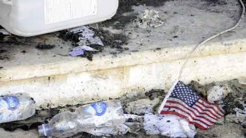 Una bandera de EEUU permanece en el suelo frente a restos carbonizados en el edificio del consulado estadounidense en Bengasi (Libia).