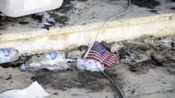 Una bandera de EEUU permanece en el suelo frente a restos carbonizados en el edificio del consulado estadounidense en Bengasi (Libia).