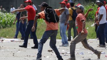 Simpatizantes, presuntamente identificados con Hugo Chávez, lanzan piedras en medio de un acto proselitista de Capriles.