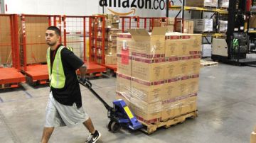 Un empleado de Amazon transporta cajas de mercancías listas para ser enviadas a los clientes.
