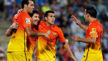 Messi es felicitado por sus compañeros en la victoria del Barcelona frente a Getafe que los coloca como más líderes que nunca.