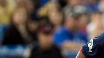 Pedro Ciriaco de los Medias Rojas de Boston deja fuera de juego a Brett Lawrie de Toronto en tercera base.