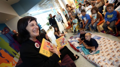 Barbara Saltzman (i), madre de  David,  lee el cuento a los pequeños  pacientes de cáncer y sus familias.