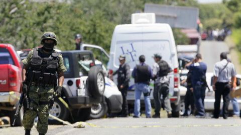 Trabajadores forenses realizan el levantamiento de 17 cadáveres ayer, en la carretera que une a Michoacán y Guadalajara, en Jalisco.